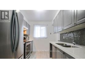 A kitchen with a stainless steel refrigerator and a sink with a faucet.
