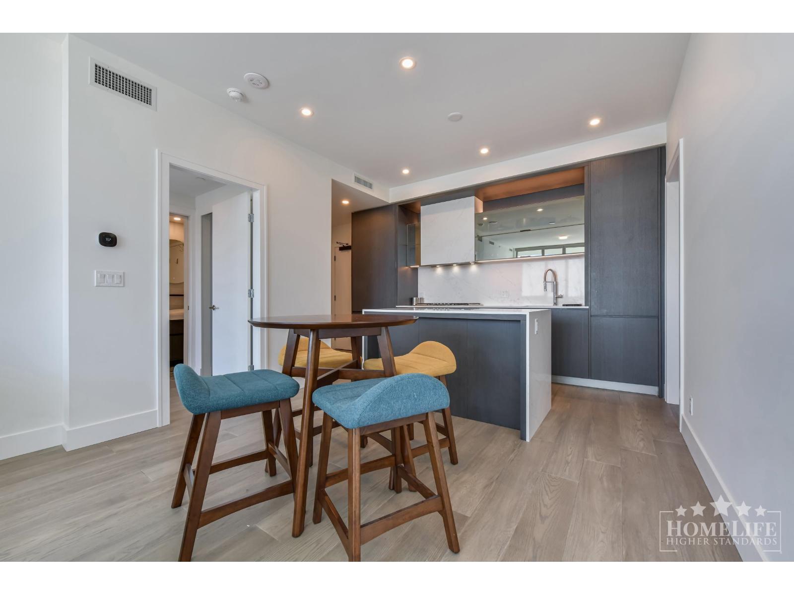 A kitchen with a table and two chairs.