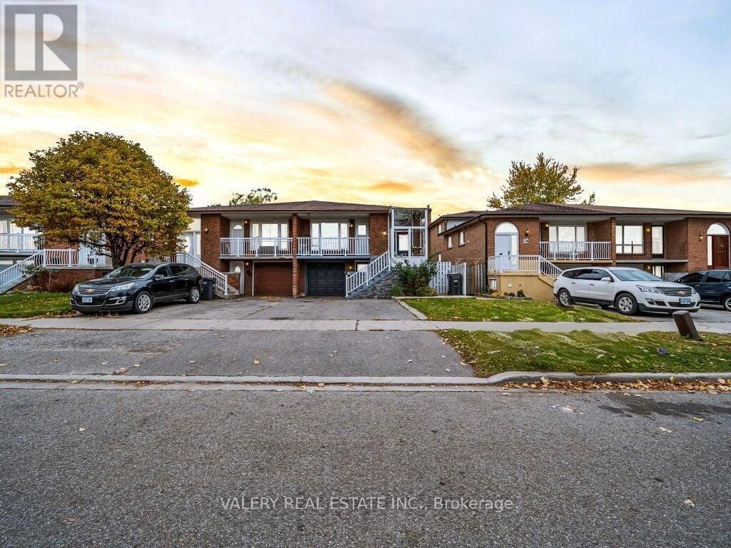 A real estate company's photo of a residential area with houses and cars.