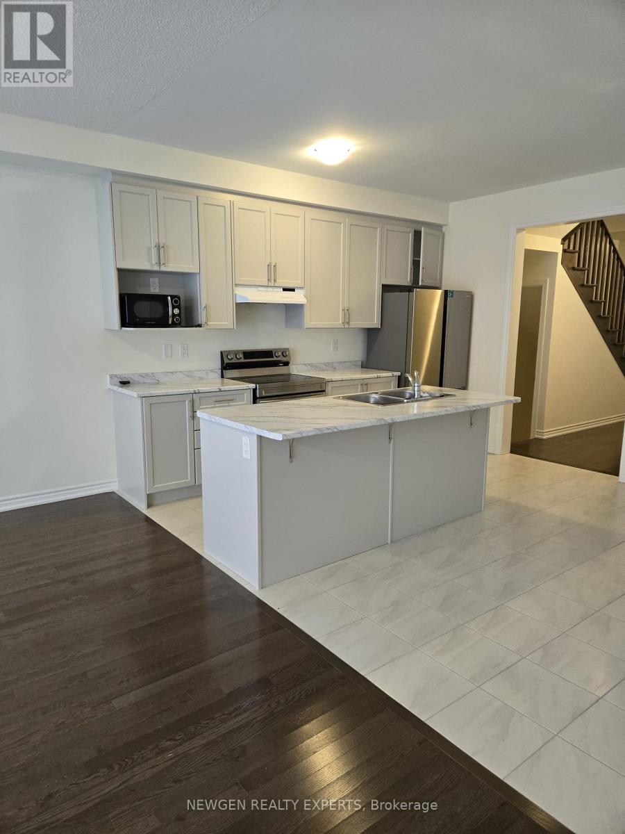 A kitchen with white cabinets and a wooden floor.