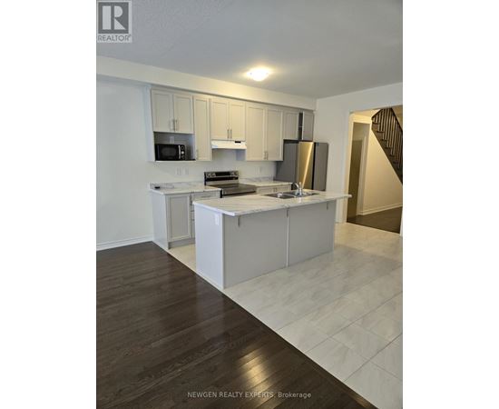 A kitchen with white cabinets and a wooden floor.