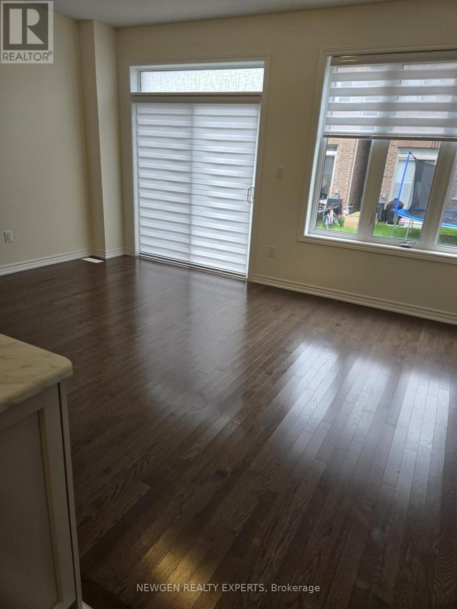 A room with wooden floors and a window with blinds.