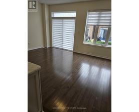 A room with wooden floors and a window with blinds.