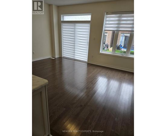 A room with wooden floors and a window with blinds.