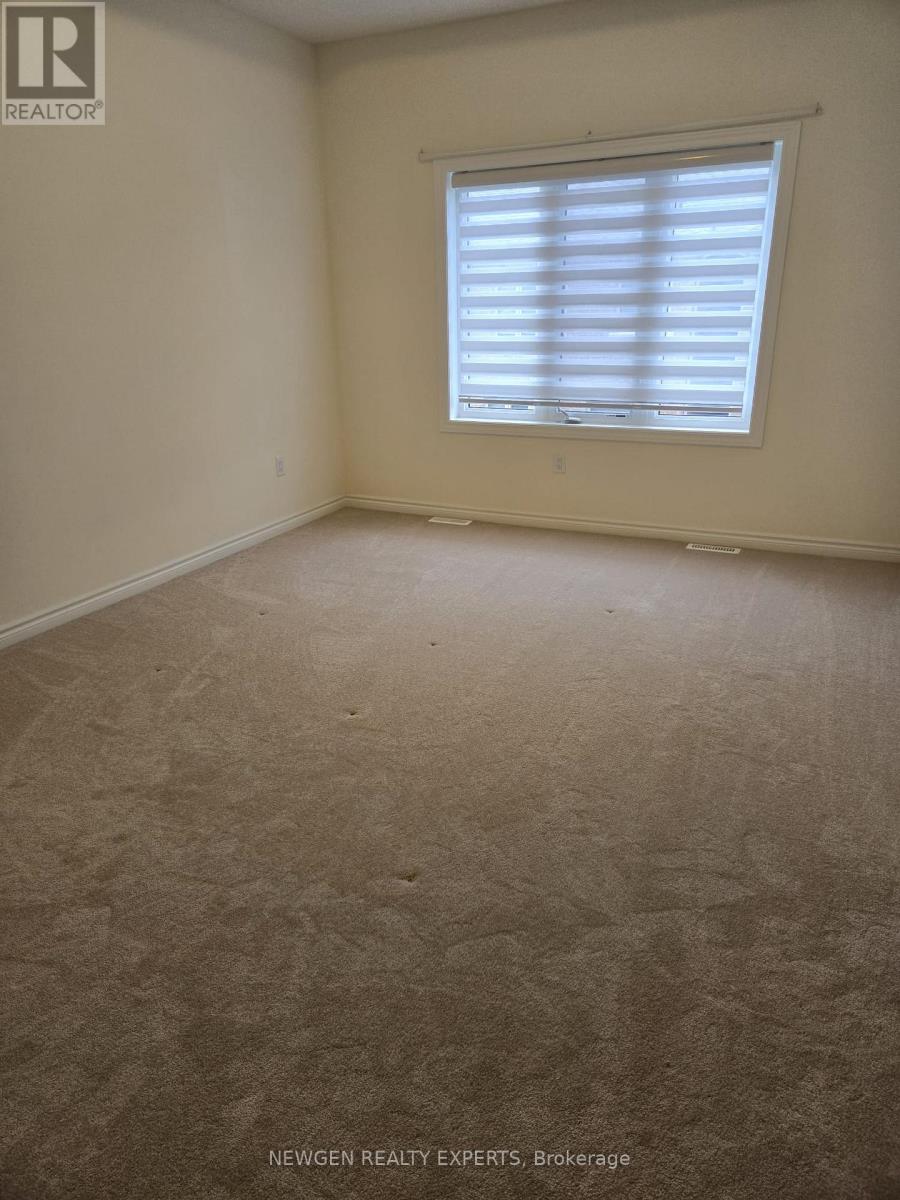 A room with a window covered by white blinds.