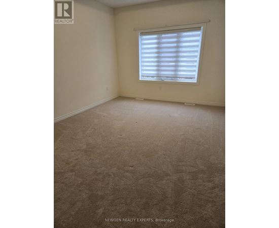A room with a window covered by white blinds.