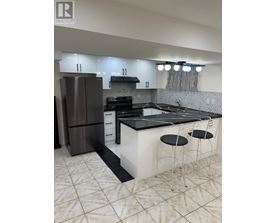 A modern kitchen with a black countertop and white cabinets.