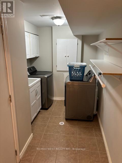 A small kitchen with a dishwasher and a trash can.
