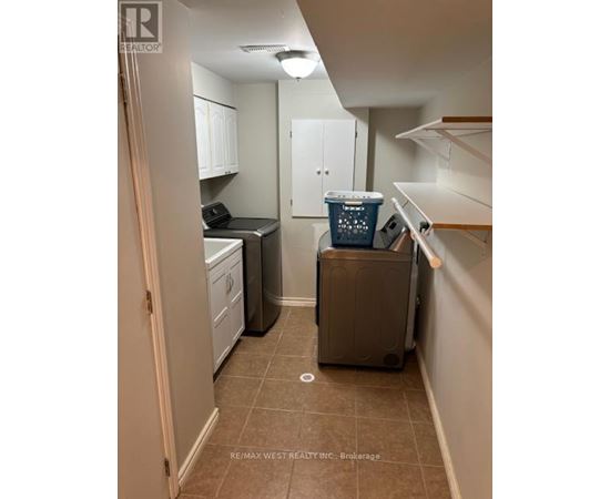 A small kitchen with a dishwasher and a trash can.