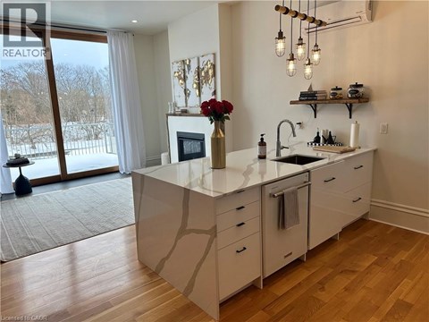 A kitchen with a large island and a view of a snowy landscape outside.