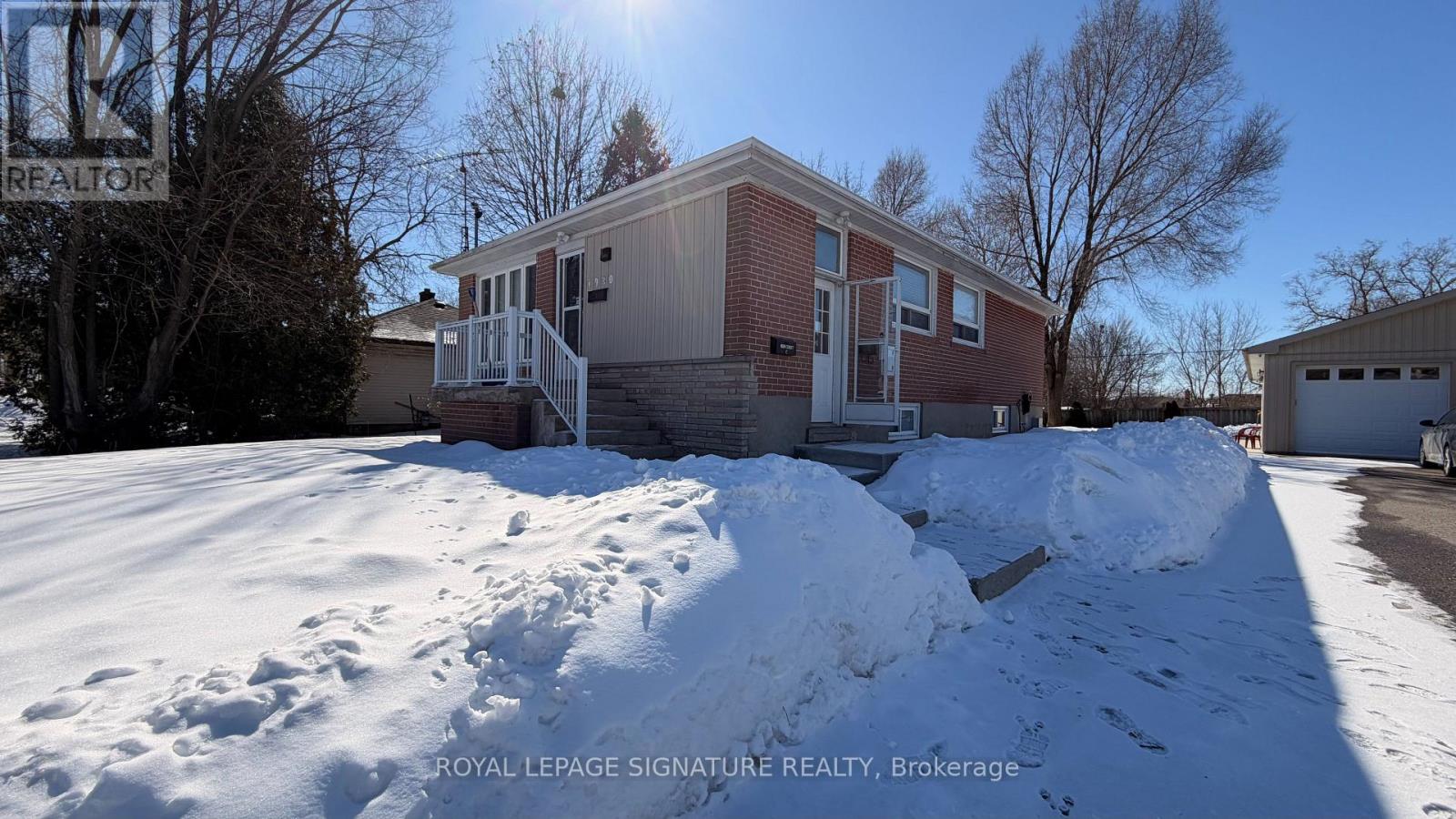 A house with a snow-covered ground in front of it.