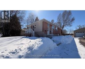 A house with a snow-covered ground in front of it.