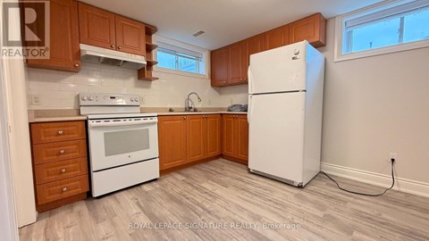 A kitchen with wooden cabinets and a white fridge.