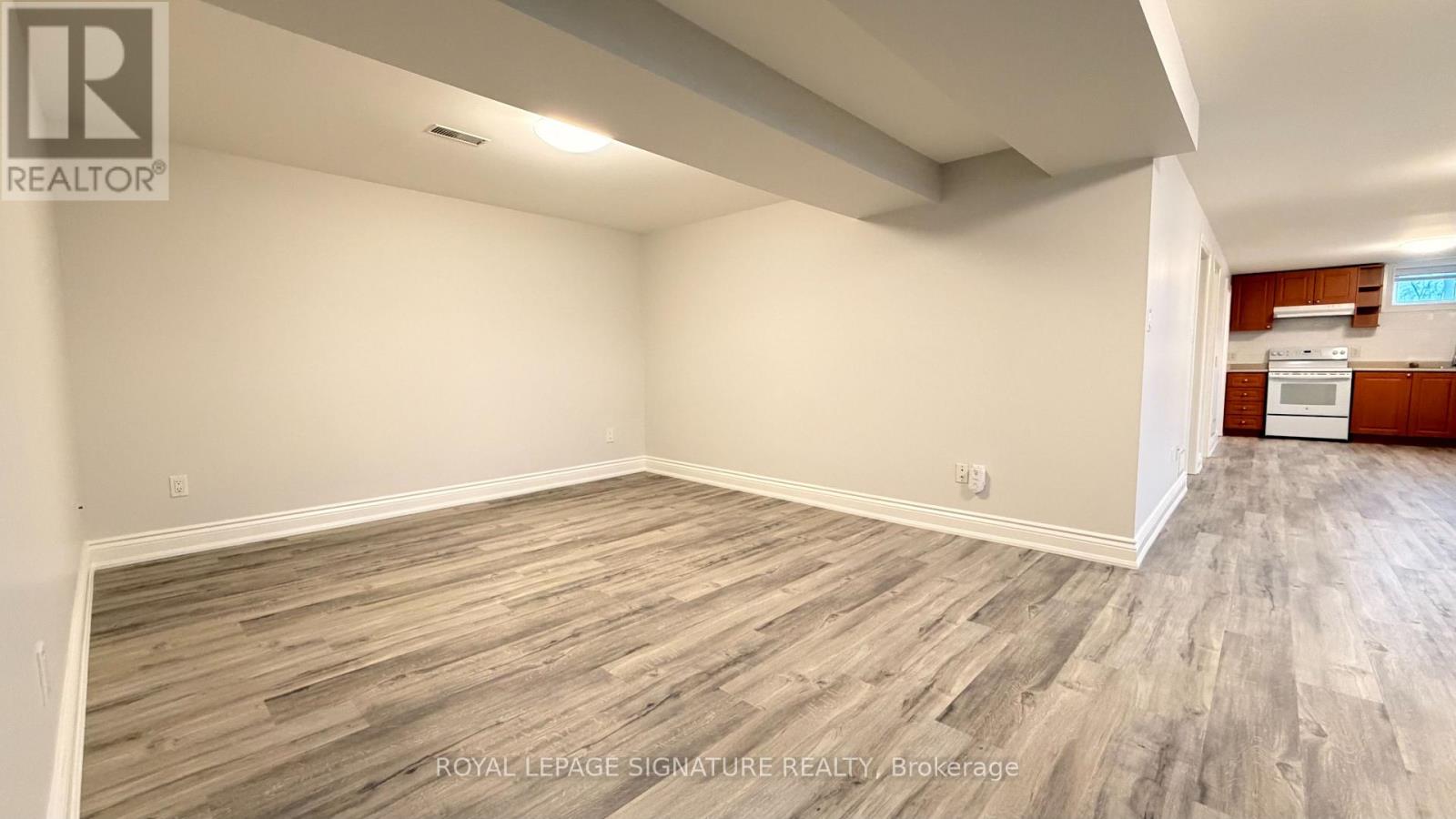 A room with wooden flooring and a white wall.