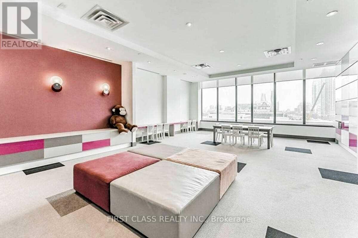 A large bedroom with a bed, a couch, and a teddy bear on the bed.