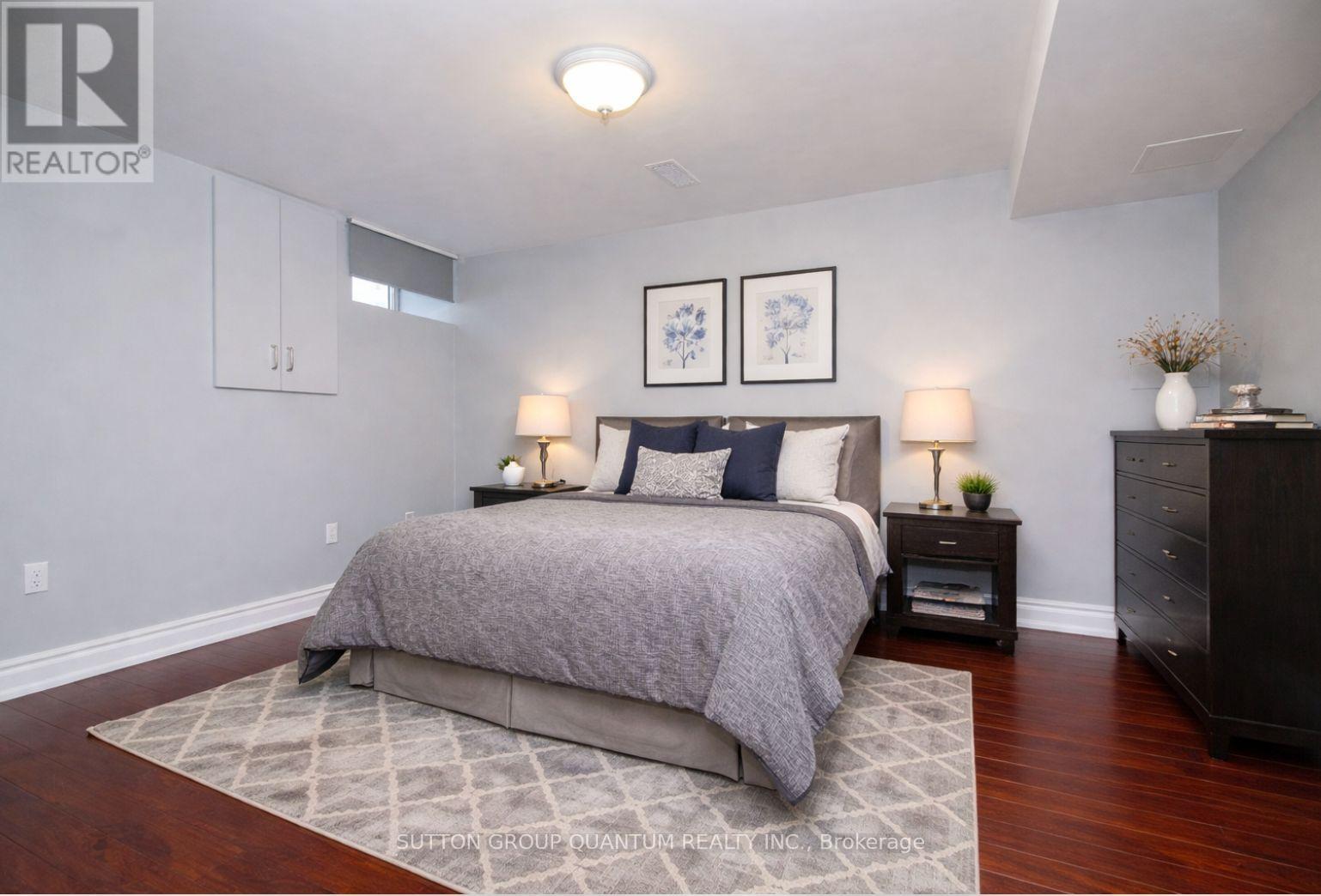 A bedroom with a large bed and a wooden floor.