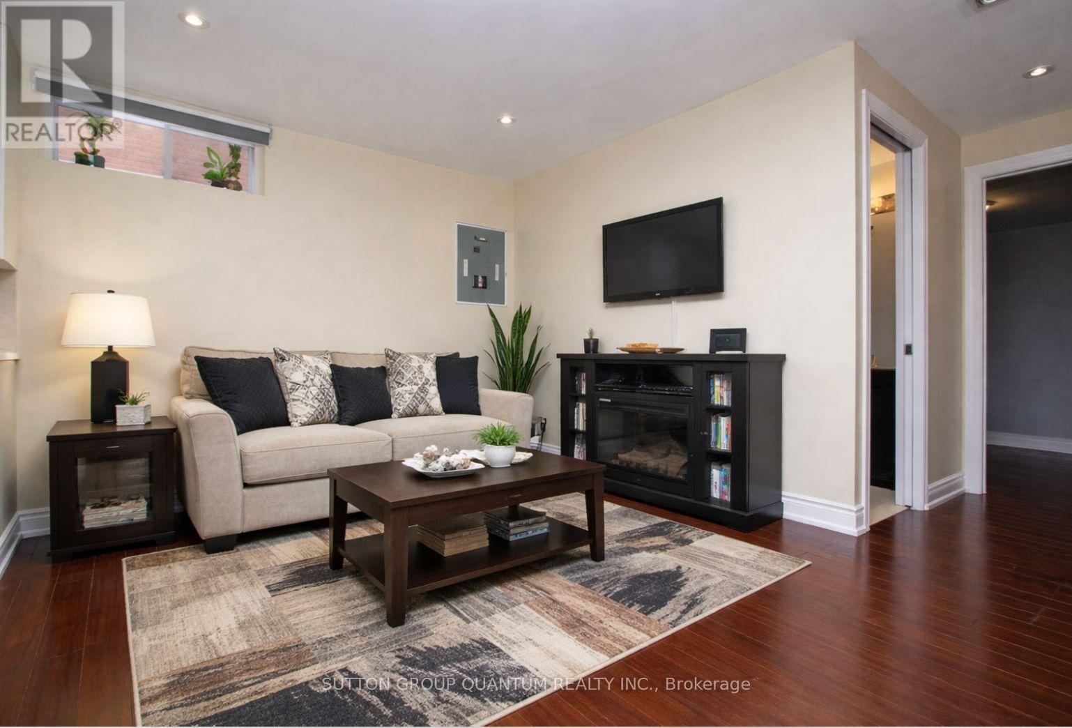A living room with a couch, coffee table, and a flat screen TV mounted on the wall.