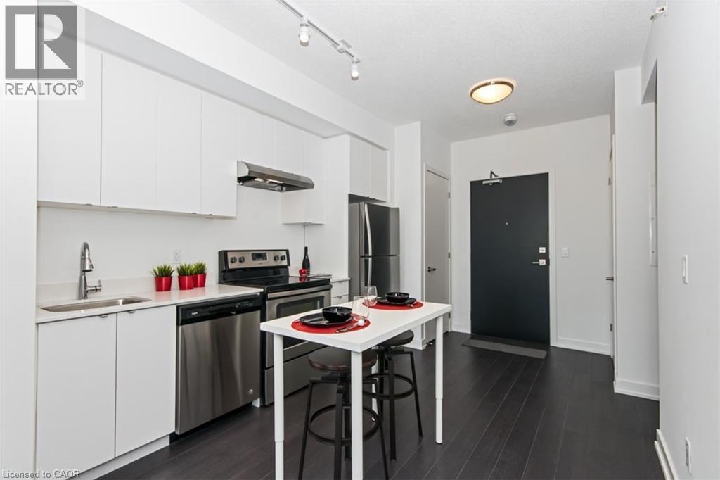 A modern kitchen with white cabinets and a black fridge.