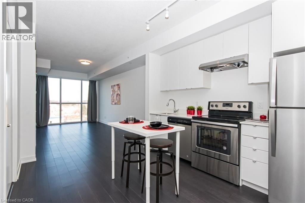 A modern kitchen with stainless steel appliances and a dining table.