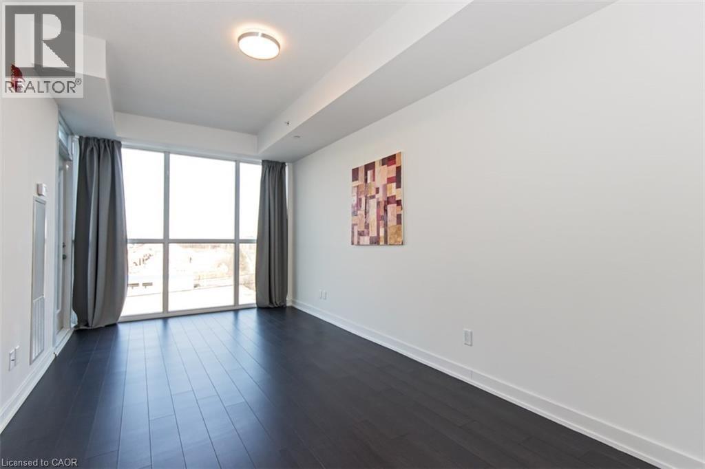 A spacious room with a large window and a painting on the wall.