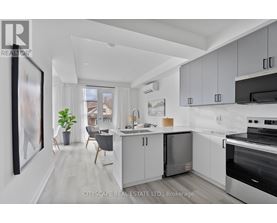 A modern kitchen with white cabinets and stainless steel appliances.