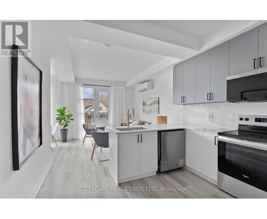 A modern kitchen with white cabinets and stainless steel appliances.
