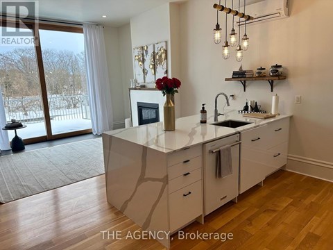 A kitchen with a large island and a view of a snowy landscape outside.