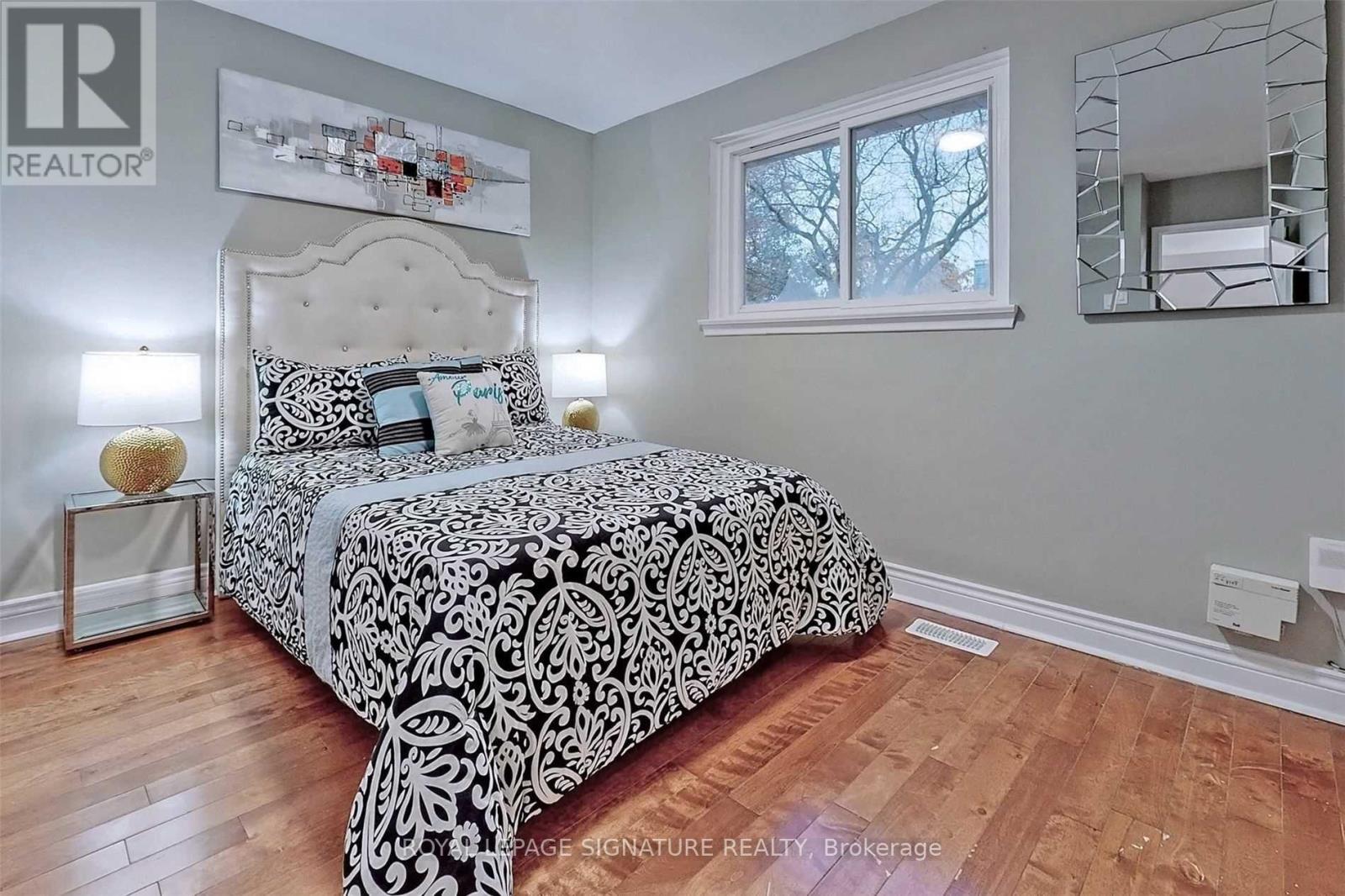 A bedroom with a large bed and a mirror on the wall.