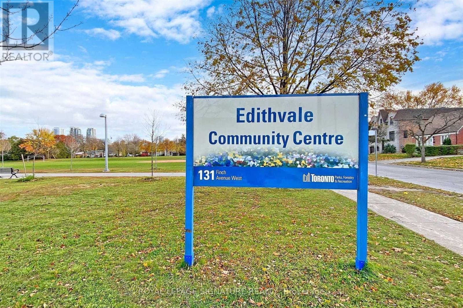 A blue sign for Edithvale Community Centre stands in a grassy area.
