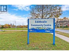 A blue sign for Edithvale Community Centre stands in a grassy area.