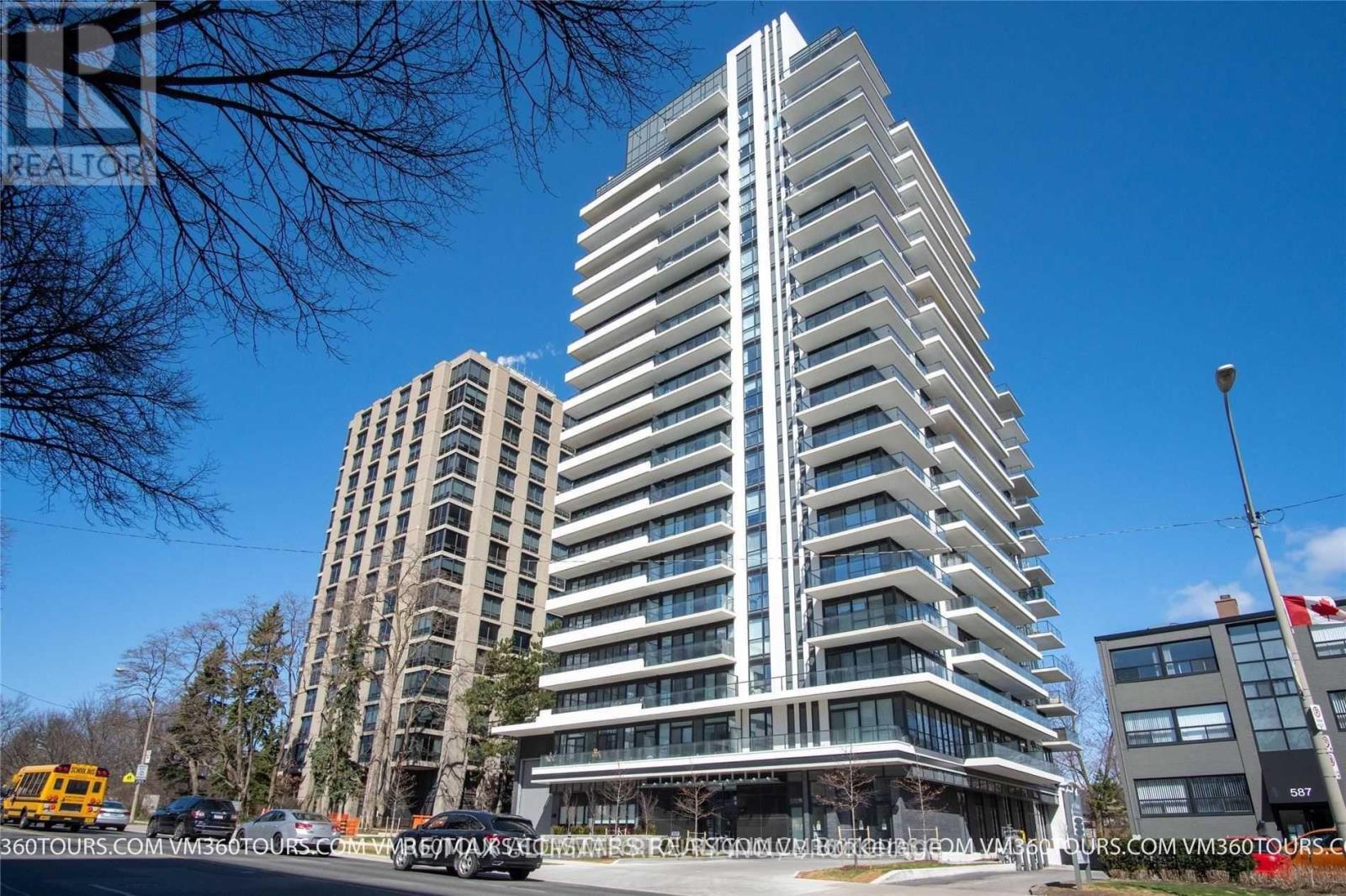 A tall, modern building with many windows is the focal point of the image.