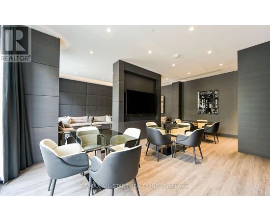 A modern living room with grey chairs and a television.