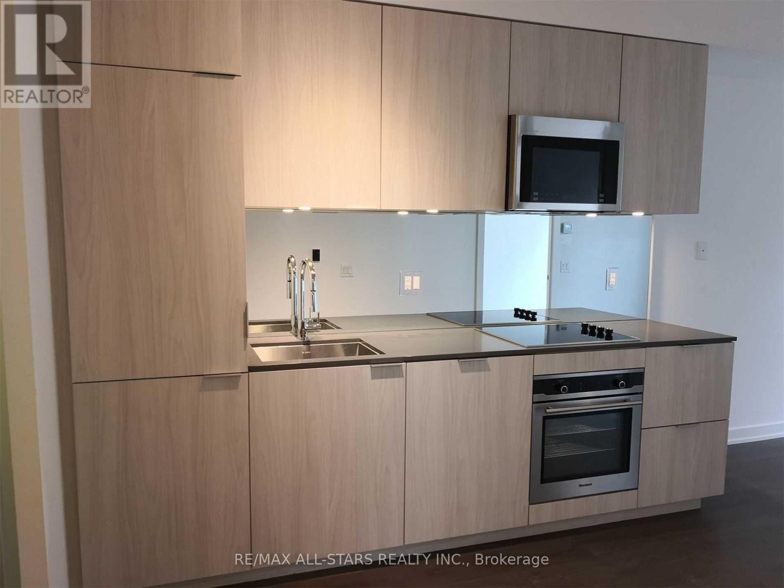 A modern kitchen with wooden cabinets and stainless steel appliances.