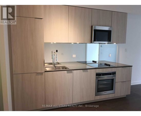 A modern kitchen with wooden cabinets and stainless steel appliances.