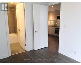 A white door is open to a kitchen.