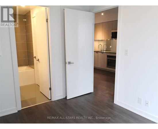 A white door is open to a kitchen.