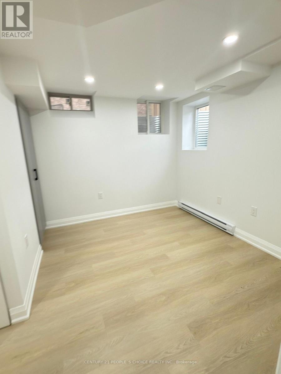 A room with light wood flooring and white walls.