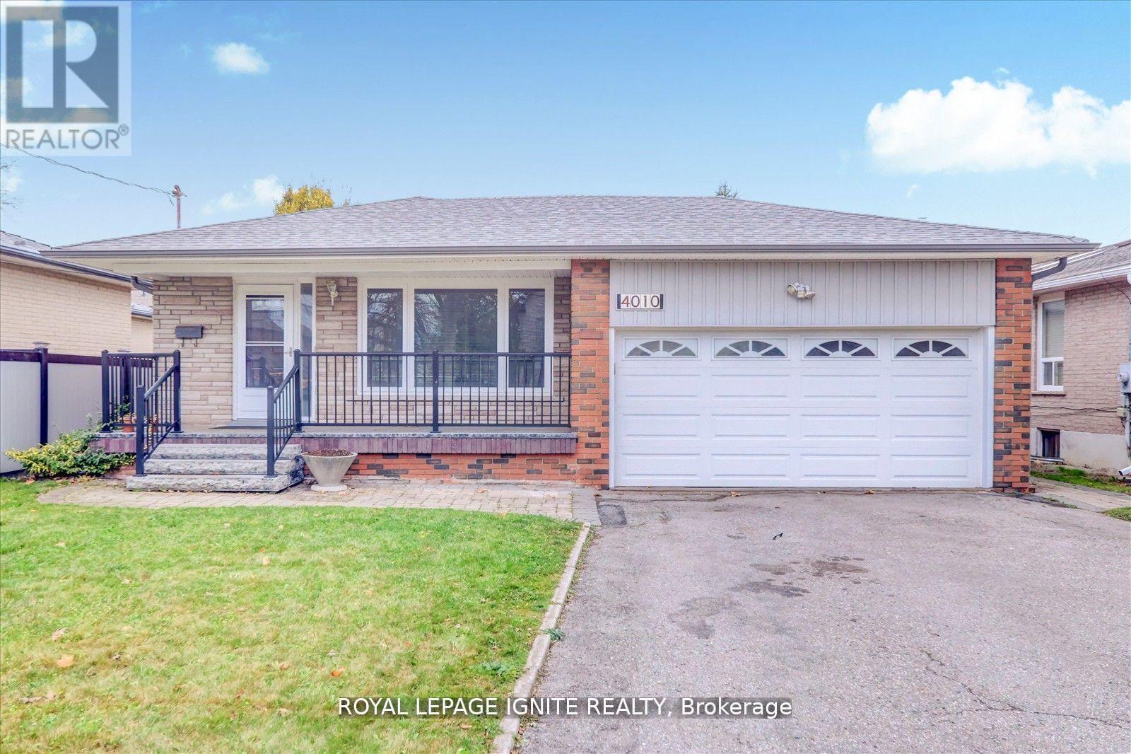 A house with a white garage door and a brick wall.