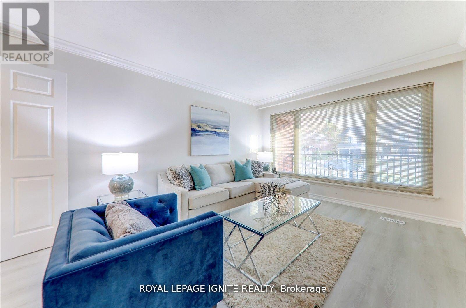 A living room with a blue couch and a glass table.