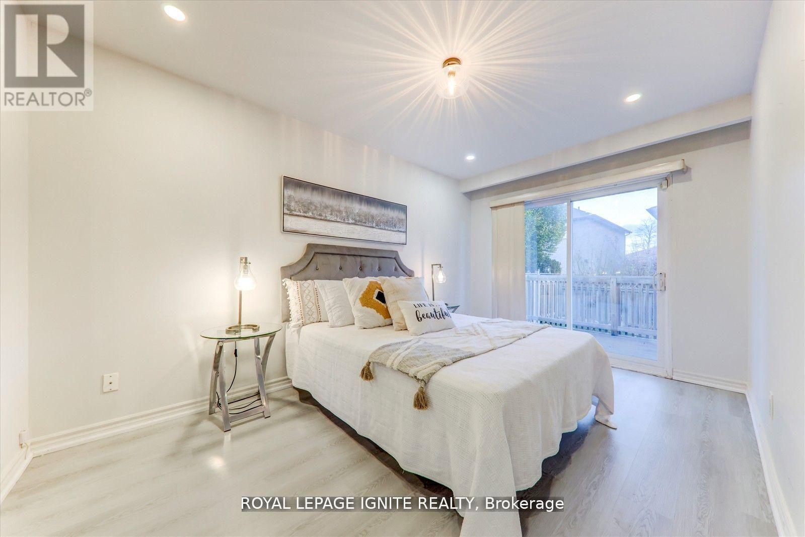 A bedroom with a bed, nightstand, and lamp.