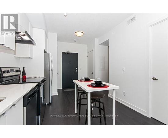 A modern kitchen with a dining table set for two.