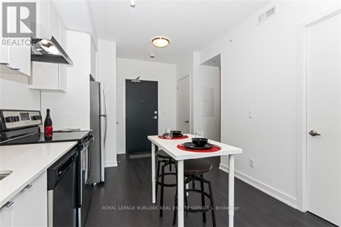 A modern kitchen with a dining table set for two.