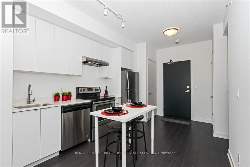A white kitchen with a black fridge and stove.