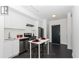 A white kitchen with a black fridge and stove.