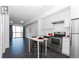 A modern kitchen with stainless steel appliances and a dining area.