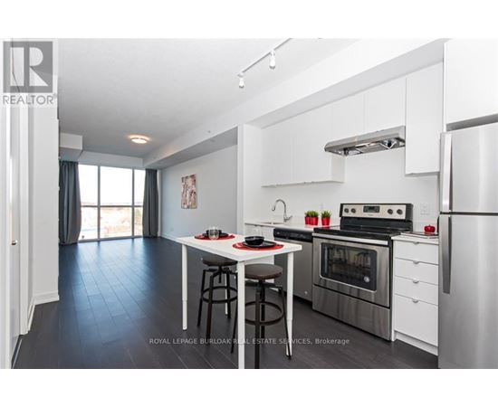A modern kitchen with stainless steel appliances and a dining area.