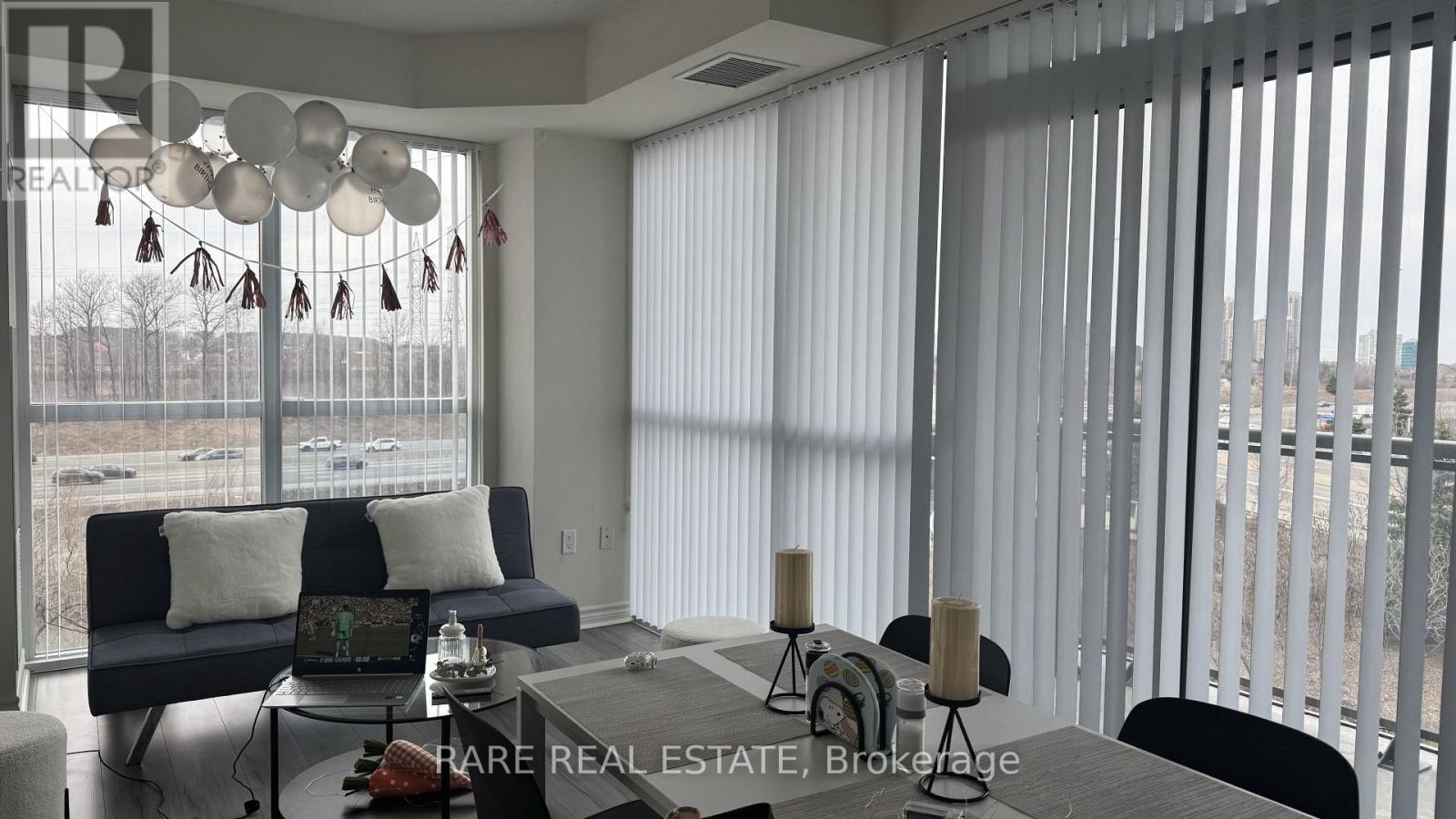 A living room with a couch, a table, and a laptop on it.