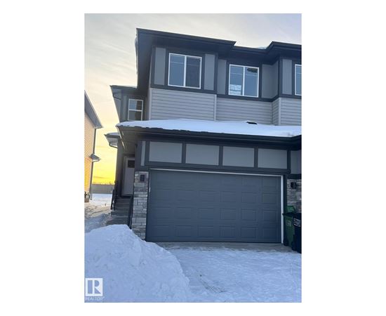 A house with a grey garage door in front of it.