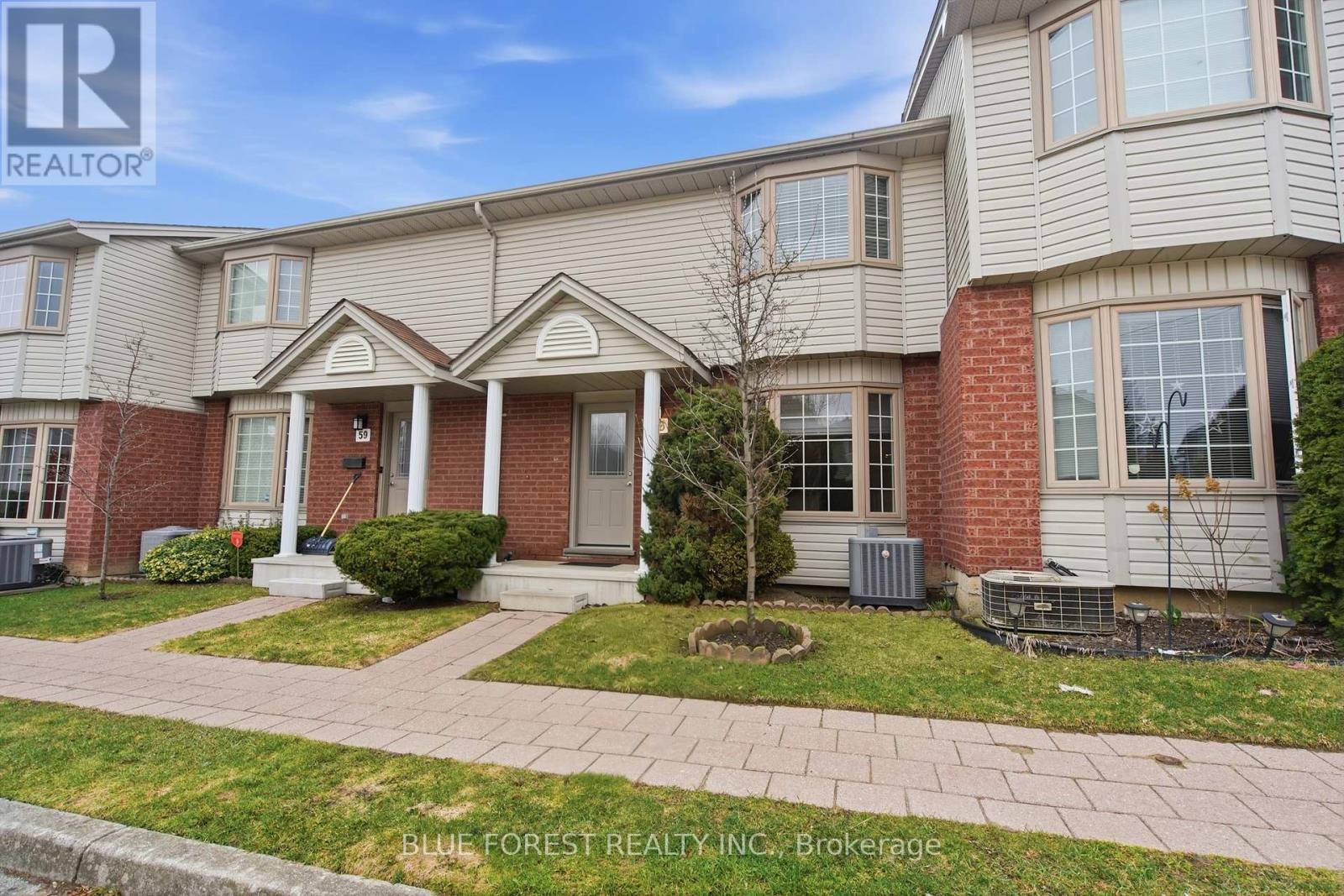 A house with a front yard and a tree in the front.