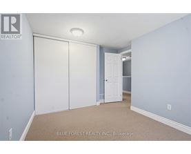 A bedroom with a white door and a carpeted floor.